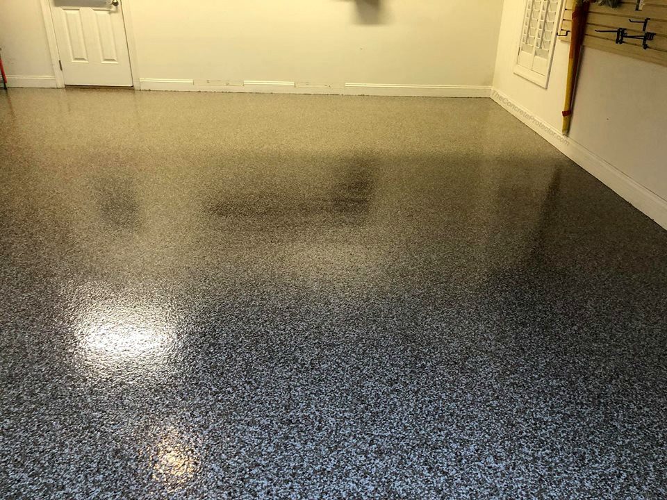 Glossy charcoal flake epoxy floor in a finished garage