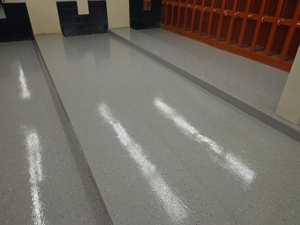 Glossy gray solid color epoxy floor with a light flake accent in a locker room